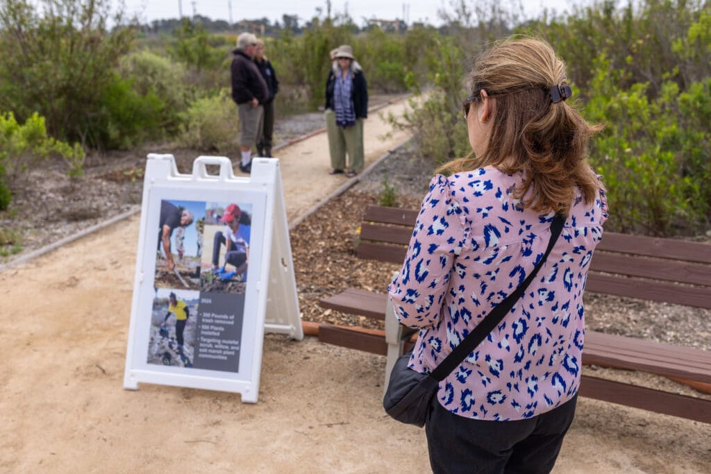 person looking at a trail sign
