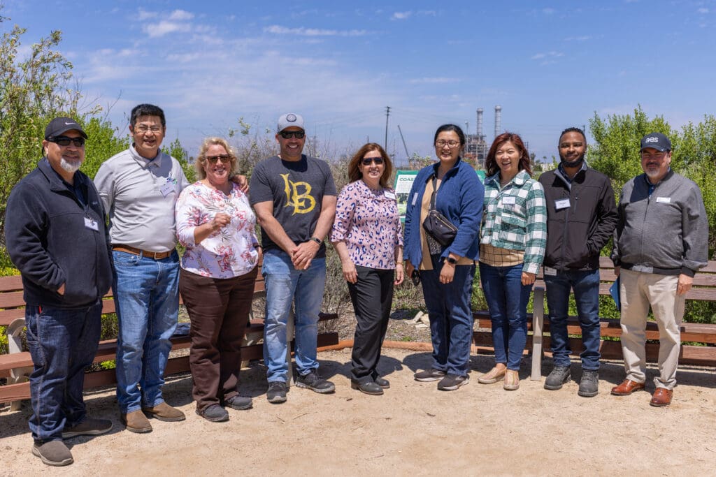 group photo of people standing near benches smiling for a photo
